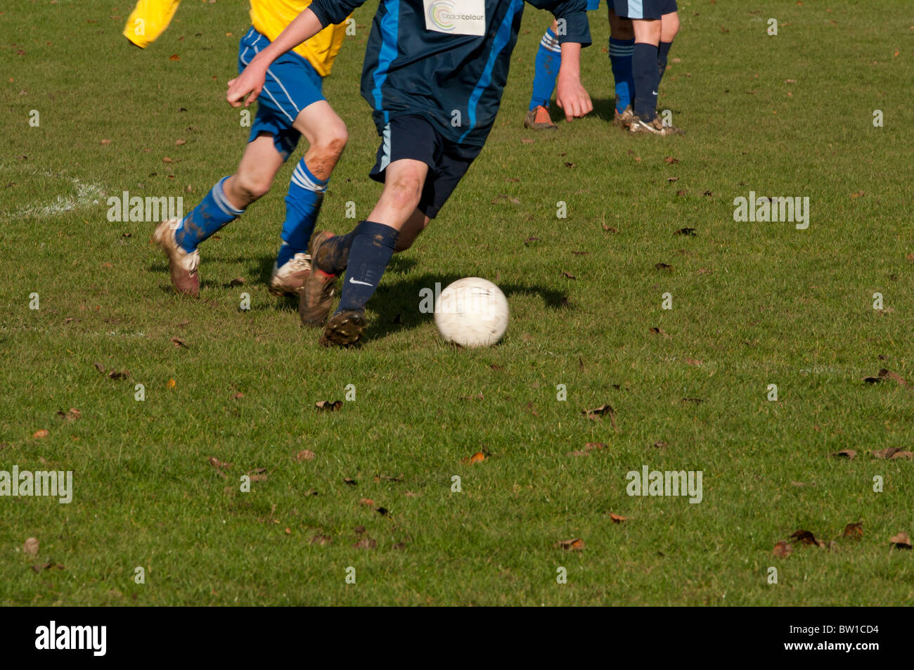Ragazzi che giocano a calcio in all'aperto campi da gioco close up di scarponi con movimento di azione stivali calci palla di gioco Foto Stock