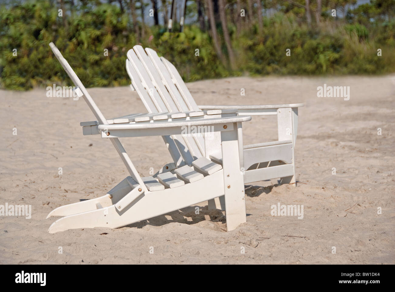 Due lonely sedie da spiaggia seduti fianco a fianco su una spiaggia di sabbia in estate Foto Stock
