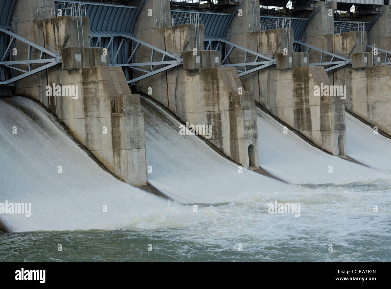 Close up che mostra le porte su una diga con acqua fluente attraverso di esse Foto Stock
