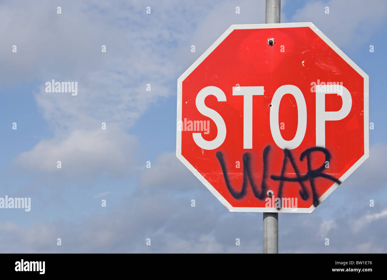 Un segnale di stop con la parola guerra dipinta su di esso. Una strana dichiarazione da coloro che si oppongono alla guerra in corso. Foto Stock