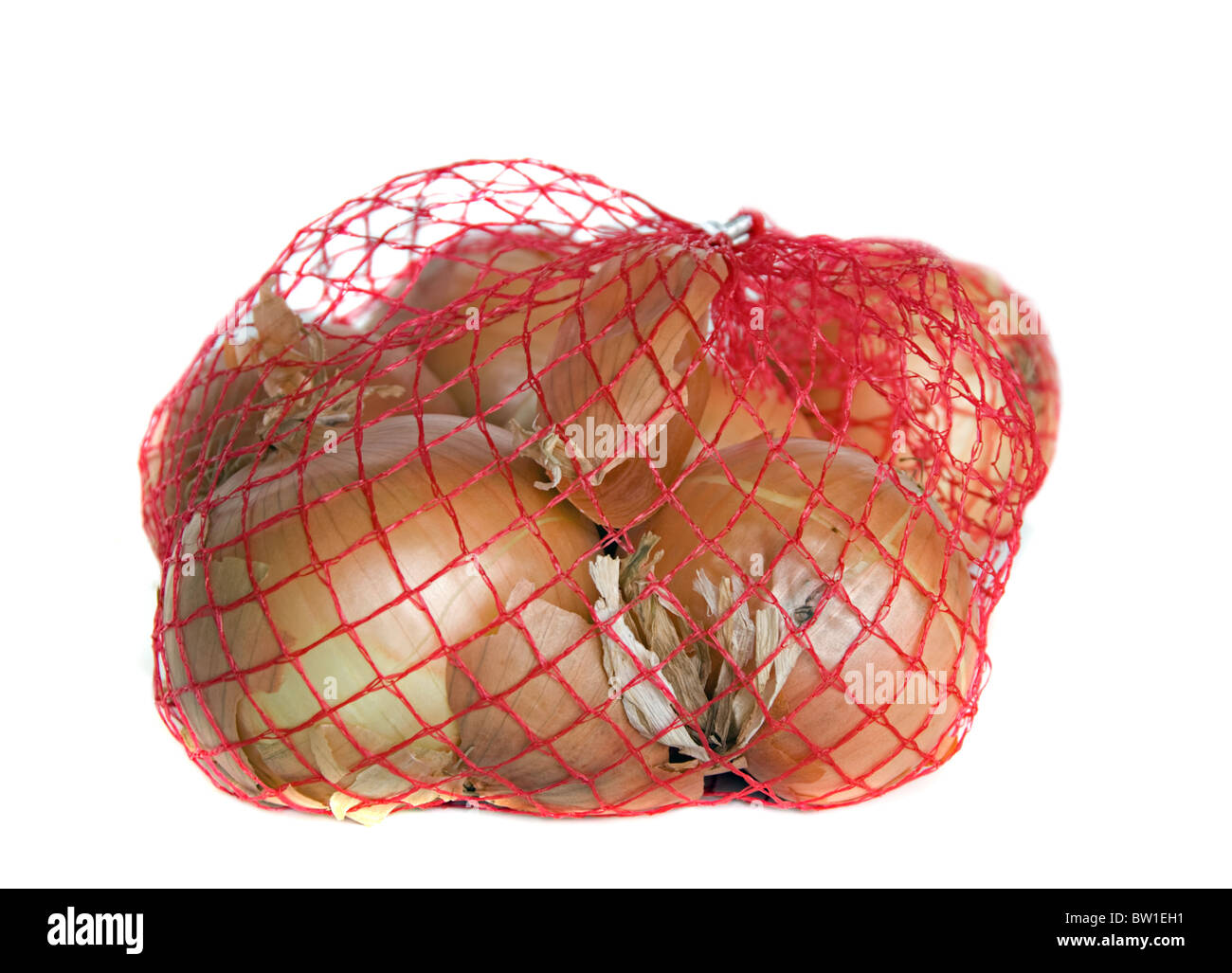 Borsa di materie di cipolle dorate in rosso net isolato su uno sfondo bianco. Le cipolle sono ricchi di fibre. Foto Stock