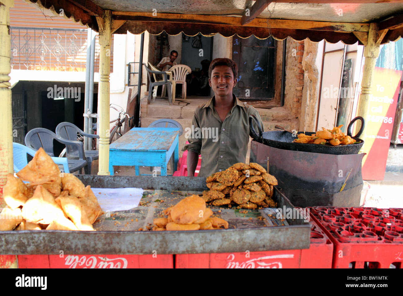 Immagine del ragazzo o del giovane che stava alla sua pressione di stallo sulla strada, vendita di cottura samosa e altri snack indiano, Hyderabad India Foto Stock