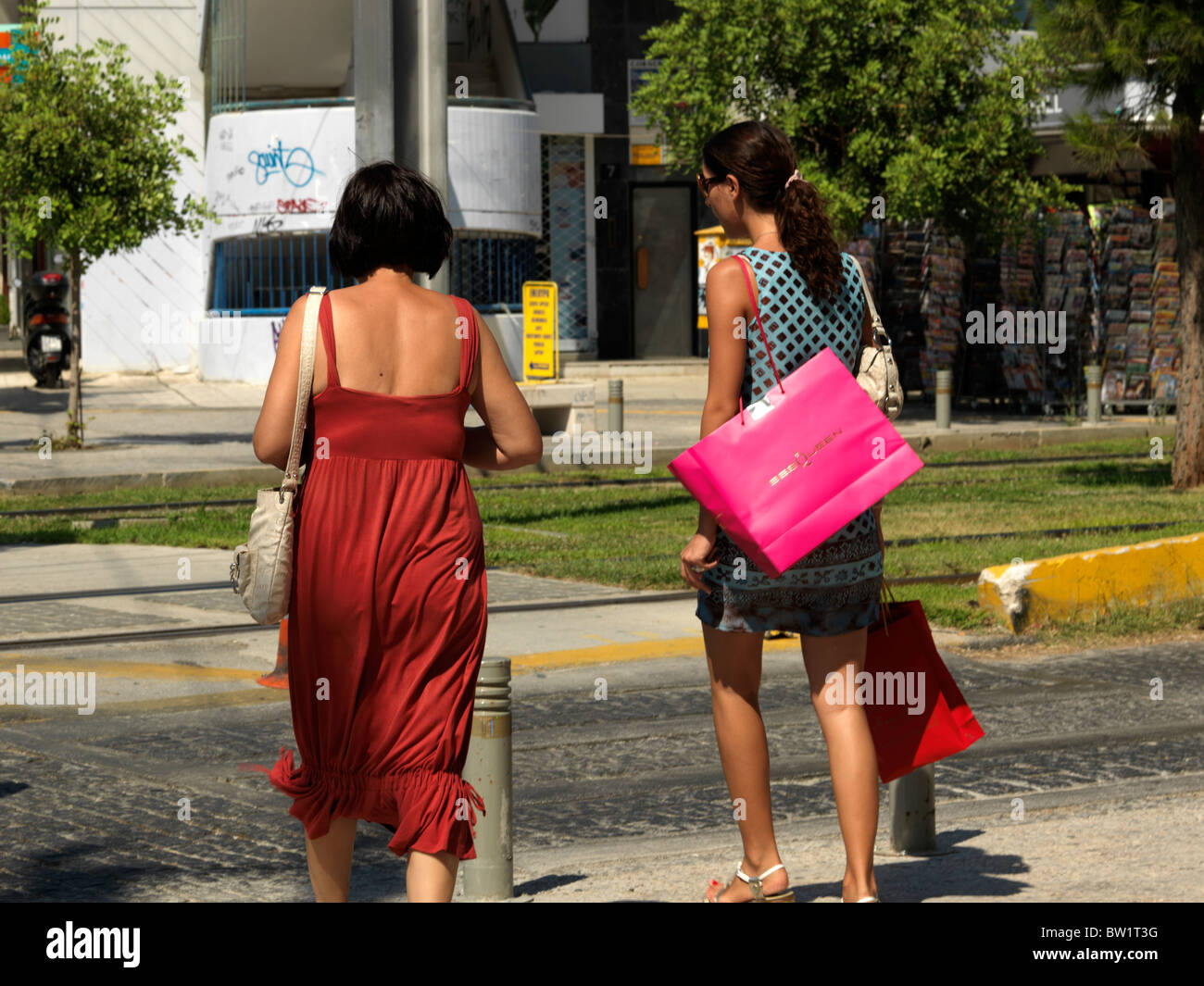 Glyfada Athens Grecia donne attraversamento strada il trasporto delle borse della spesa Foto Stock