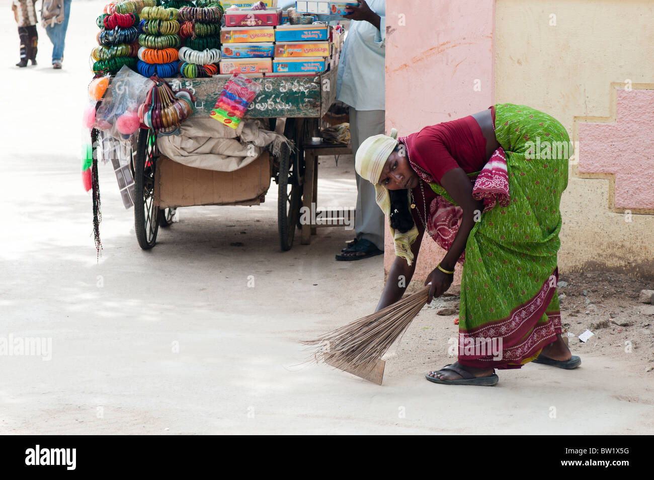 Donna indiana a spazzare le strade di Puttaparthi, Andhra Pradesh, India Foto Stock