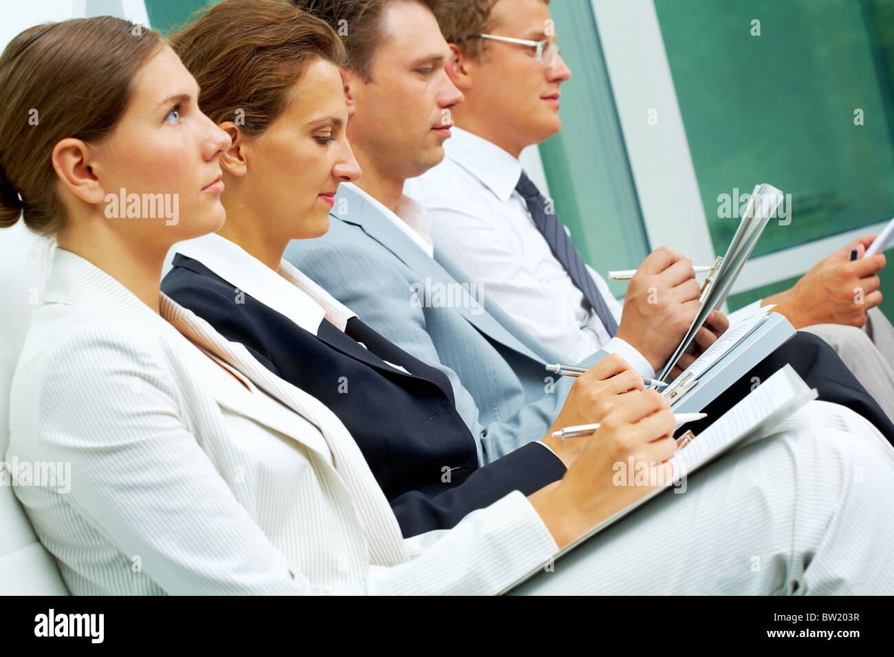 Fila di gente di affari la scrittura di conferenza in conferenza Foto Stock