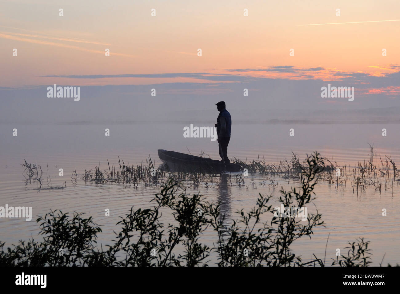 Il pescatore di uscire a pescare sui tradizionali punt all'alba, Biebrza marsh, Polonia, maggio 2008. Foto Stock