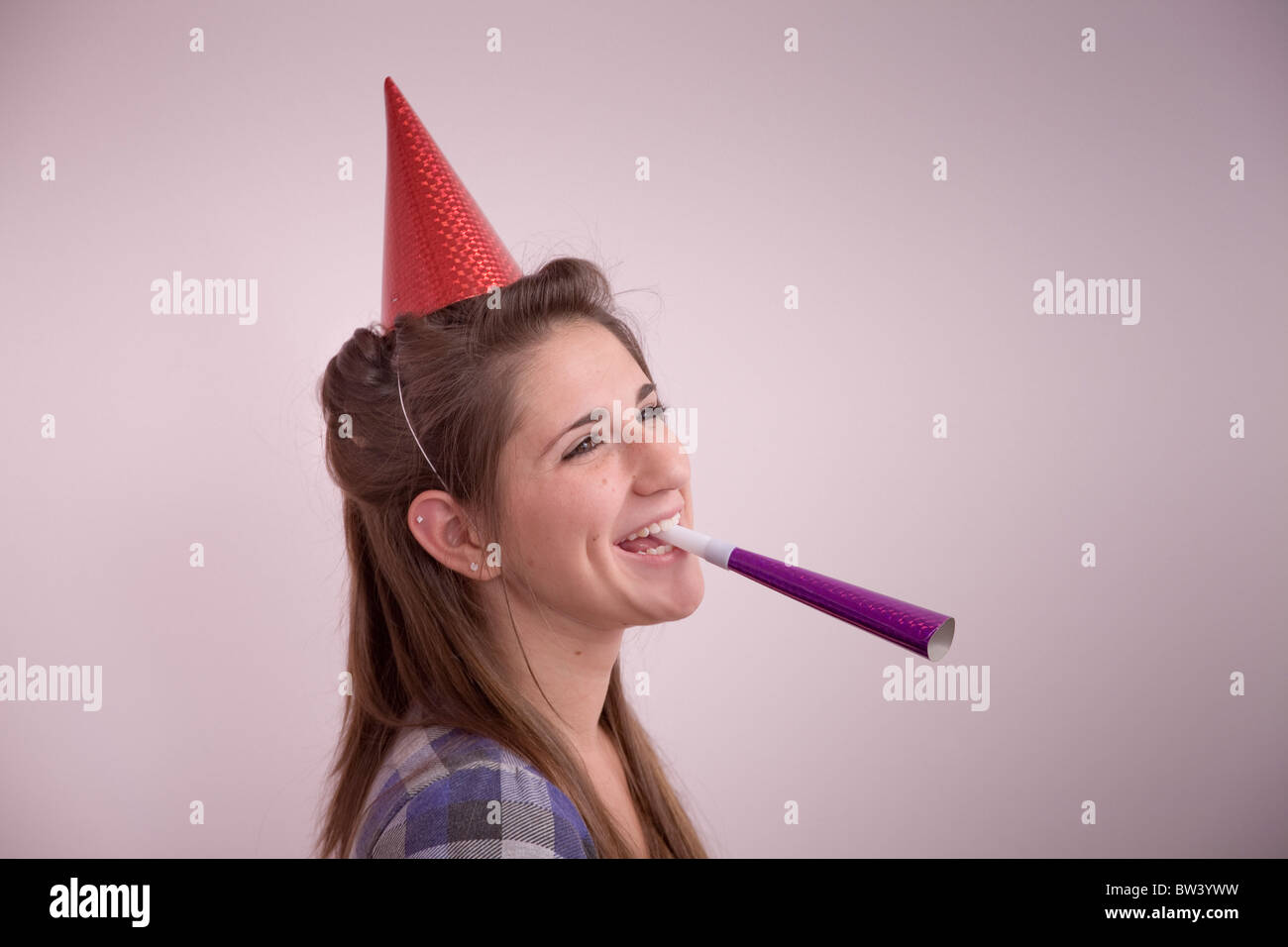 Teen girl (Età 15) con un party hat e noisemaker Foto Stock