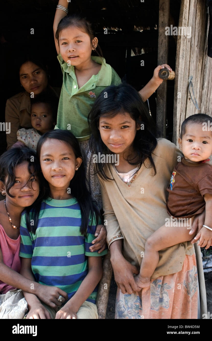 Un gruppo di baraccati vivono in condizioni di povertà sono in posa per un ritratto di gruppo davanti a una capanna di legno in Kampong Cham, Cambogia. Foto Stock