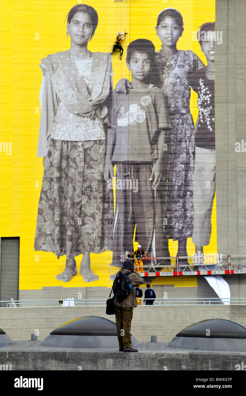 Fotografo a scattare foto di operai che fissa gigantesca foto a parete per Aviva 'Voi siete il Big Picture" Campagna pubblicitaria Foto Stock