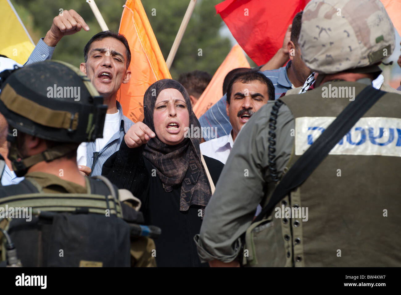Una donna Palestinese affronta i soldati israeliani in una protesta non violenta contro il popolo israeliano barriera di separazione. Foto Stock
