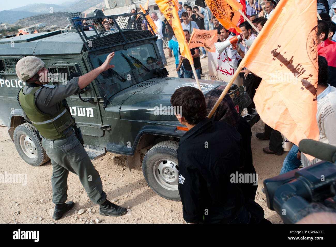 Attivisti palestinesi affrontare i soldati israeliani in una protesta non violenta contro il popolo israeliano barriera di separazione in Cisgiordania. Foto Stock
