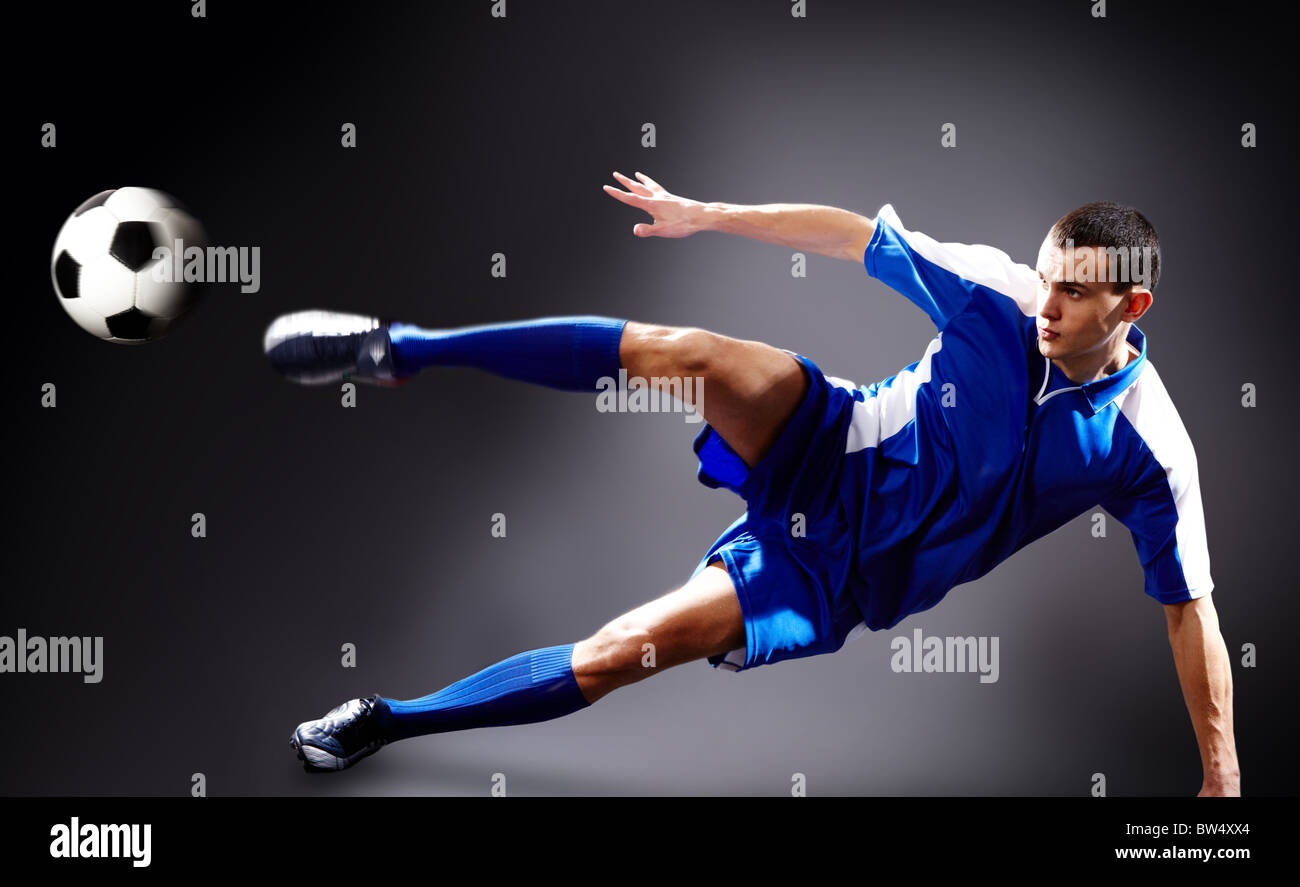 Immagine del giocatore di calcio facendo volare kick con sfera Foto Stock