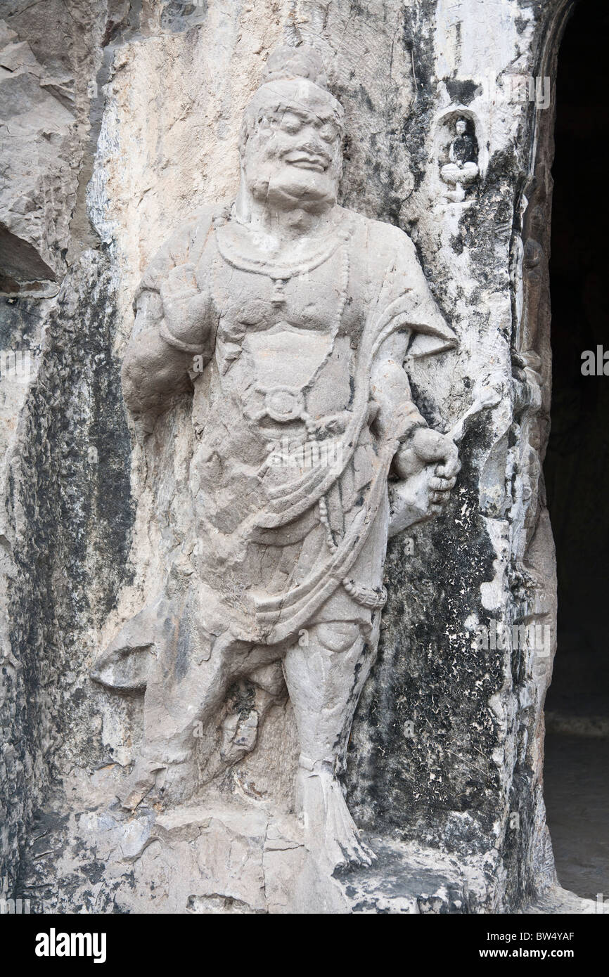 Una pietra scolpita la statua scolpita nella roccia, le Grotte di Longmen e grotte, Luoyang, nella provincia di Henan, Cina Foto Stock