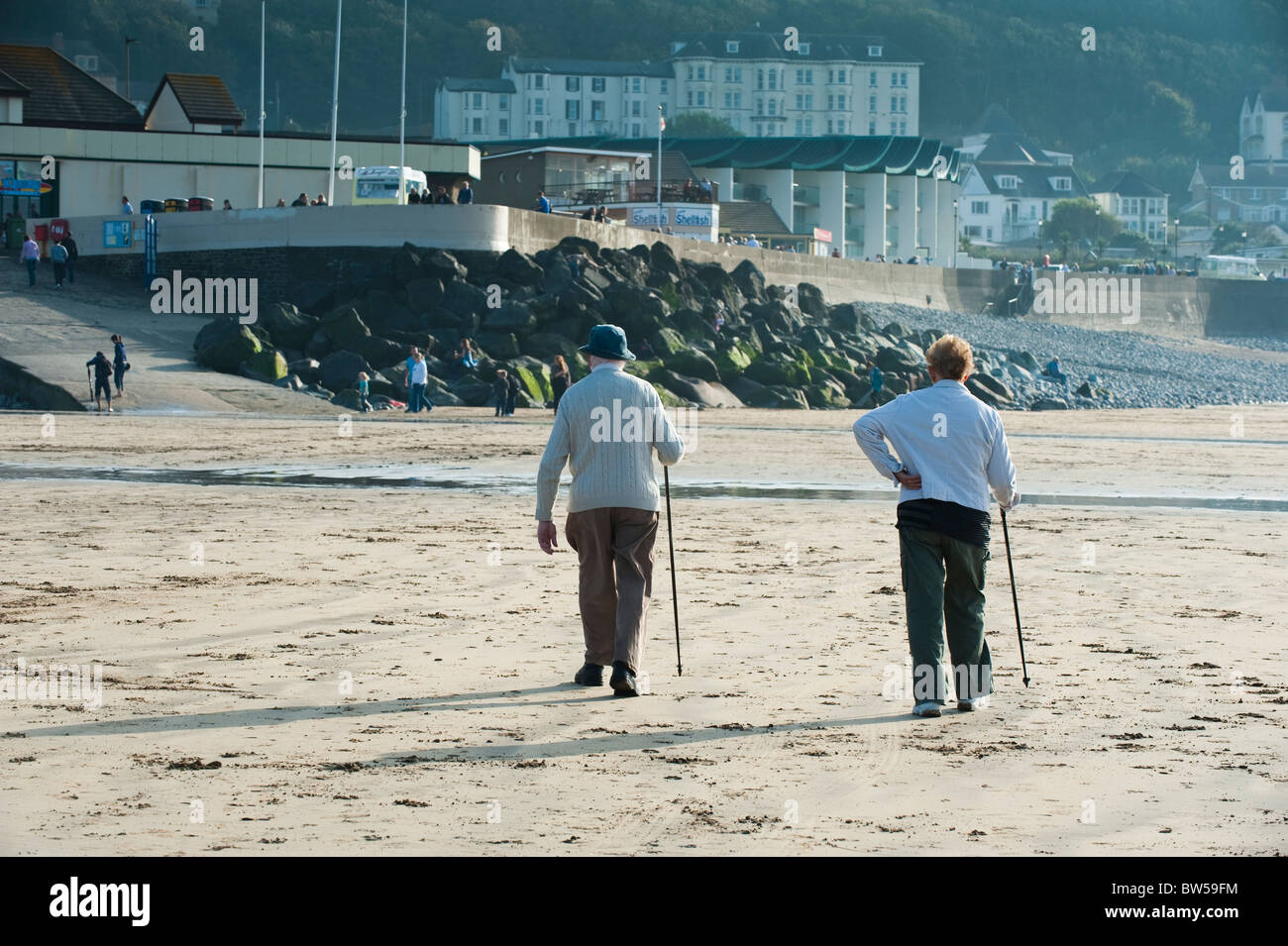 Il vecchio uomo e donna camminando sulla spiaggia a Condino Devon UK Foto Stock