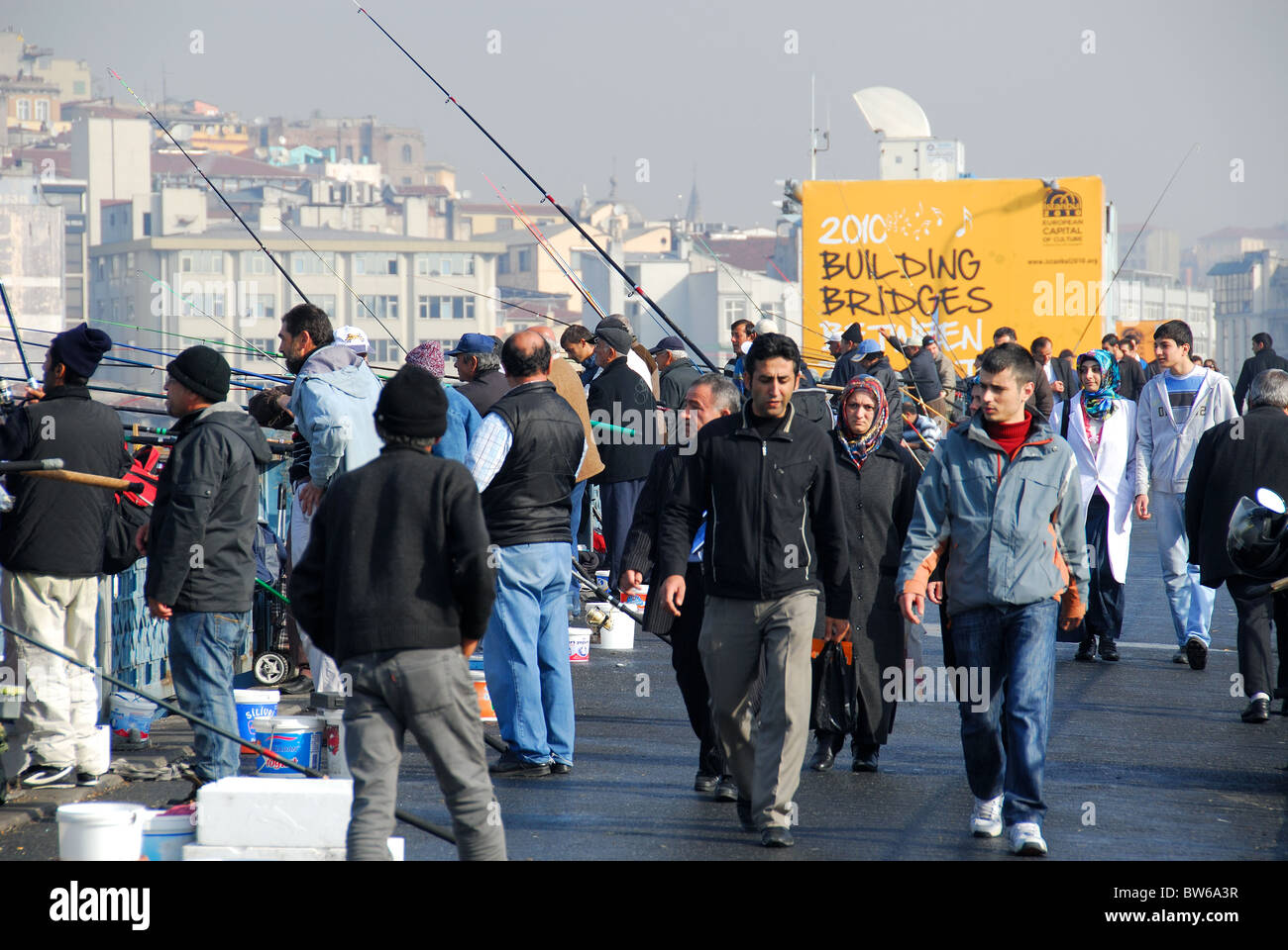 ISTANBUL, Turchia. Le persone camminare su e da pesca, il Ponte di Galata, con Karakoy distretto in background. 2010. Foto Stock