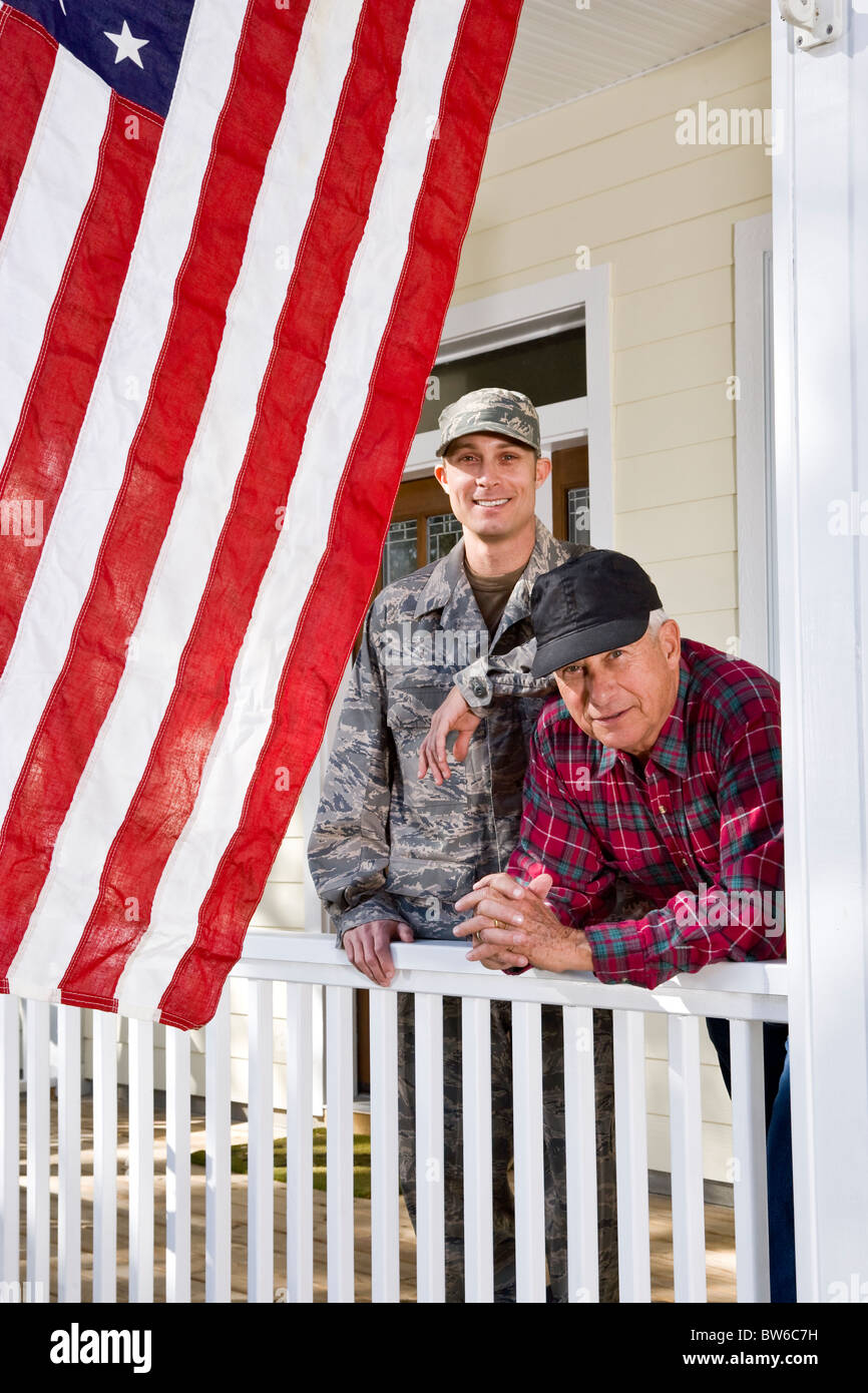 Uomo in uniforme militare con il padre con la bandiera americana Foto Stock