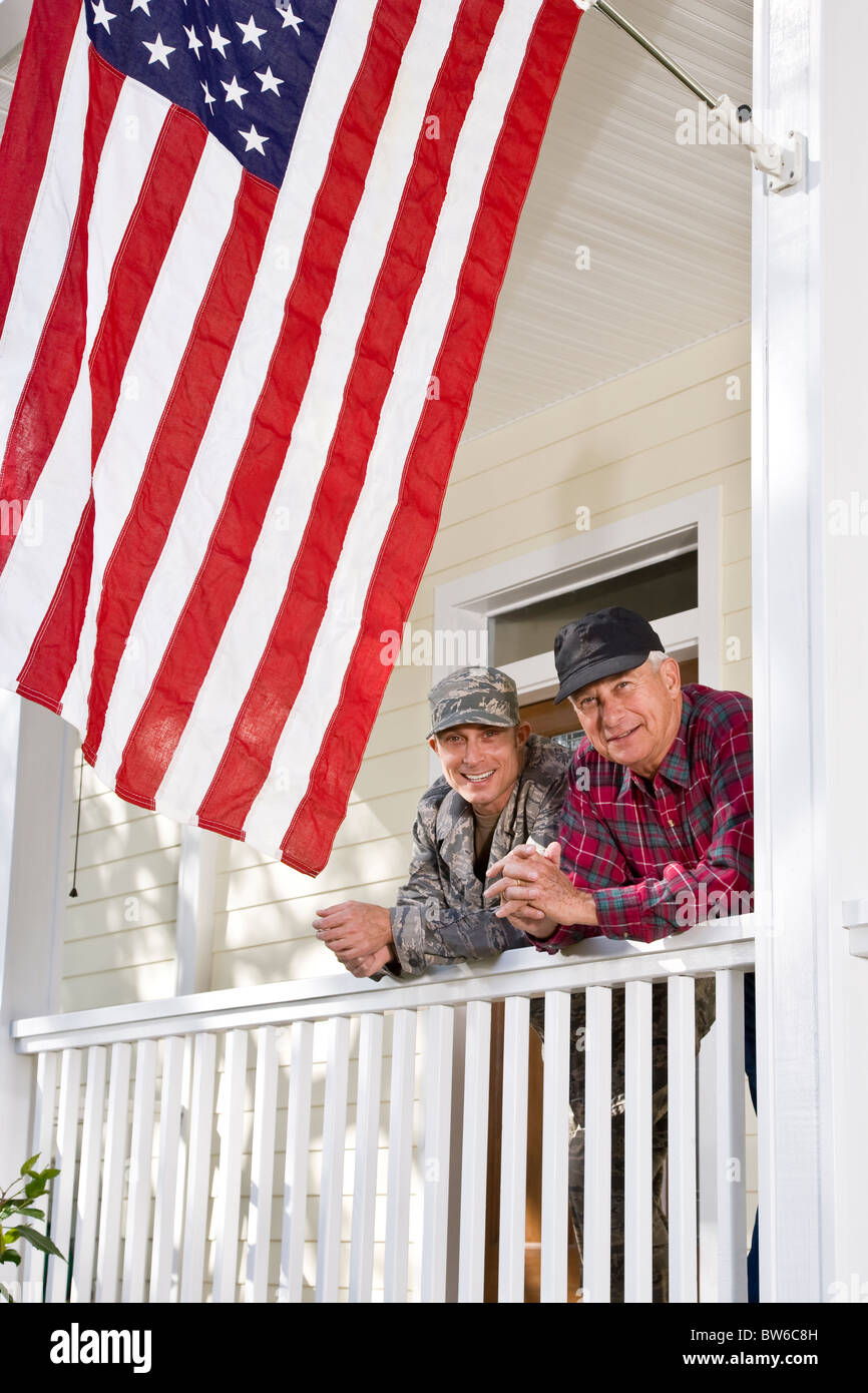 Uomo in uniforme militare con il padre con la bandiera americana Foto Stock