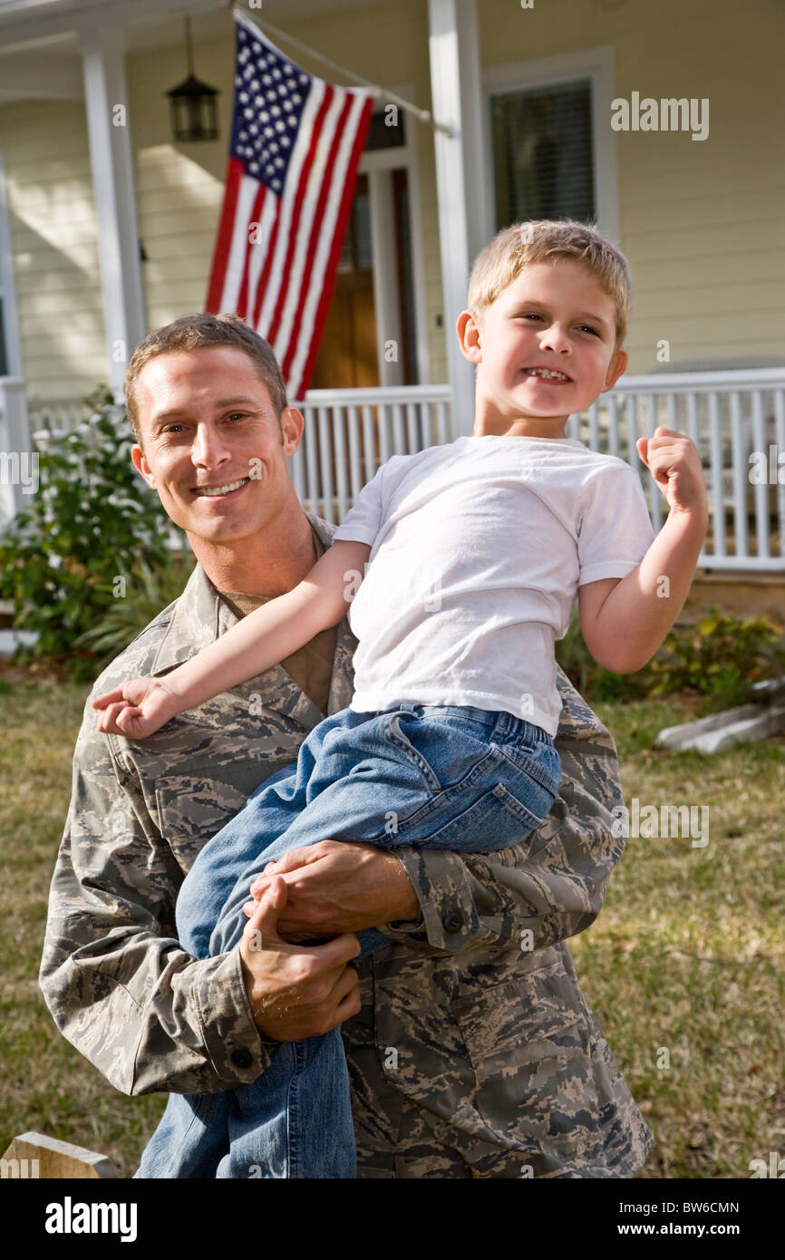 Felice papà militare a casa con il figlio Foto Stock
