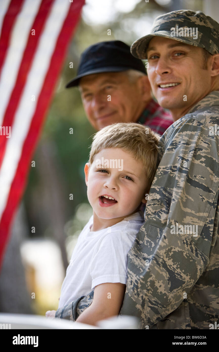 Famiglia di militari sul portico di casa con la bandiera americana Foto Stock