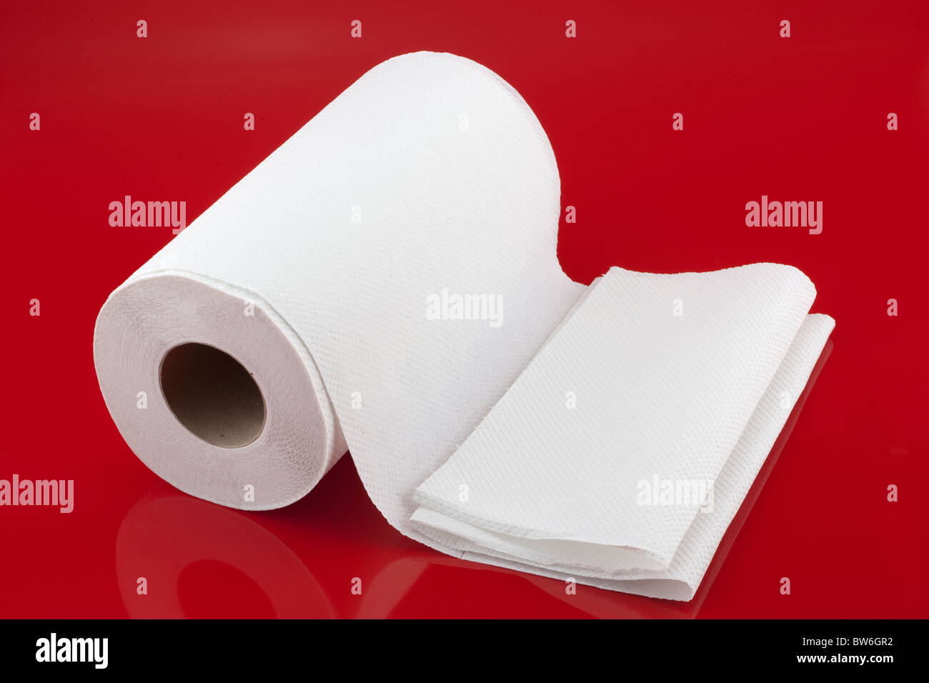 Rotolo di carta bianca da cucina su sfondo rosso Foto Stock