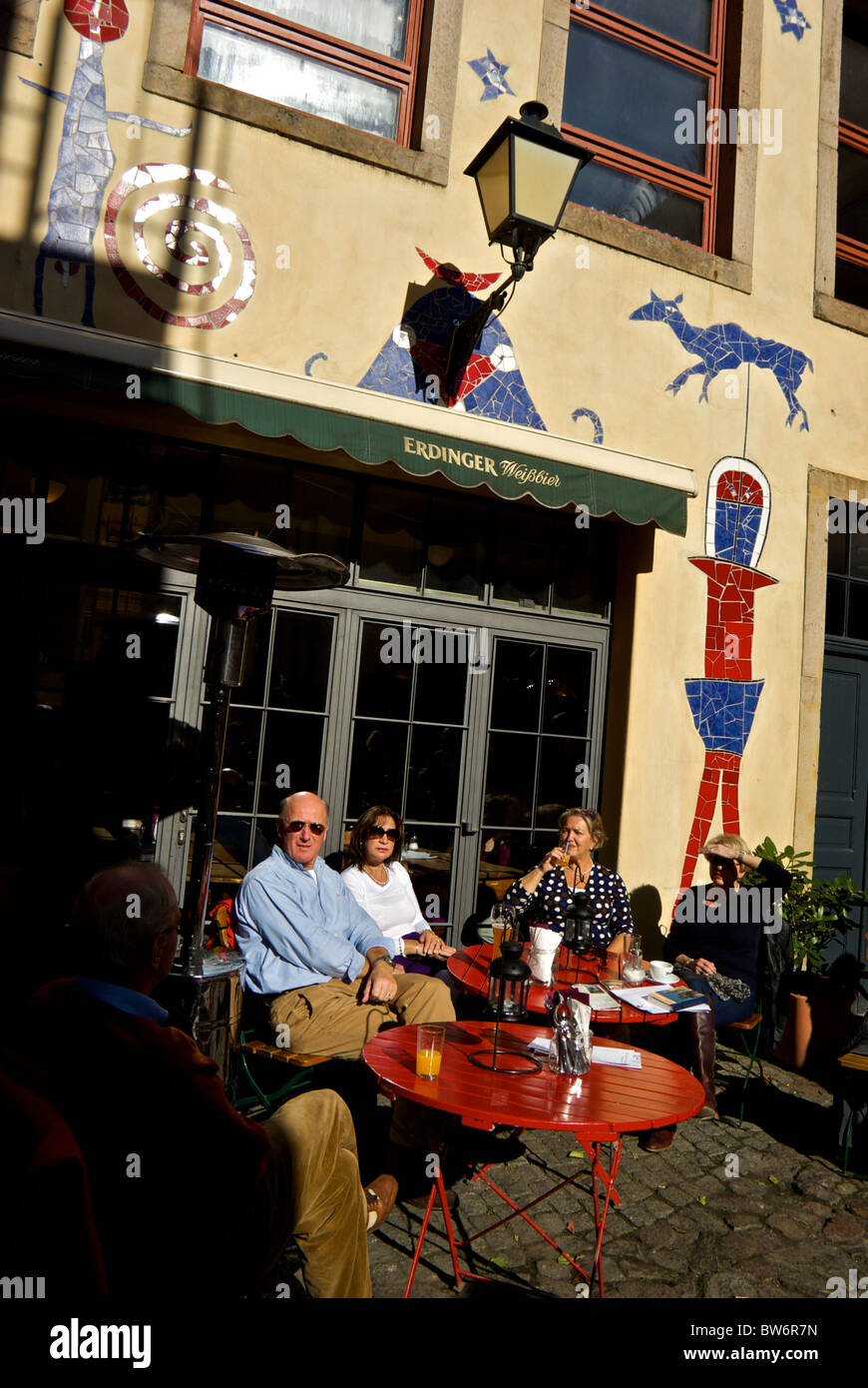 I turisti godersi drink cafe patio esterno Cortile di animali mitici mosaici funky bassorilievi Dresda città nuova neustadt Foto Stock