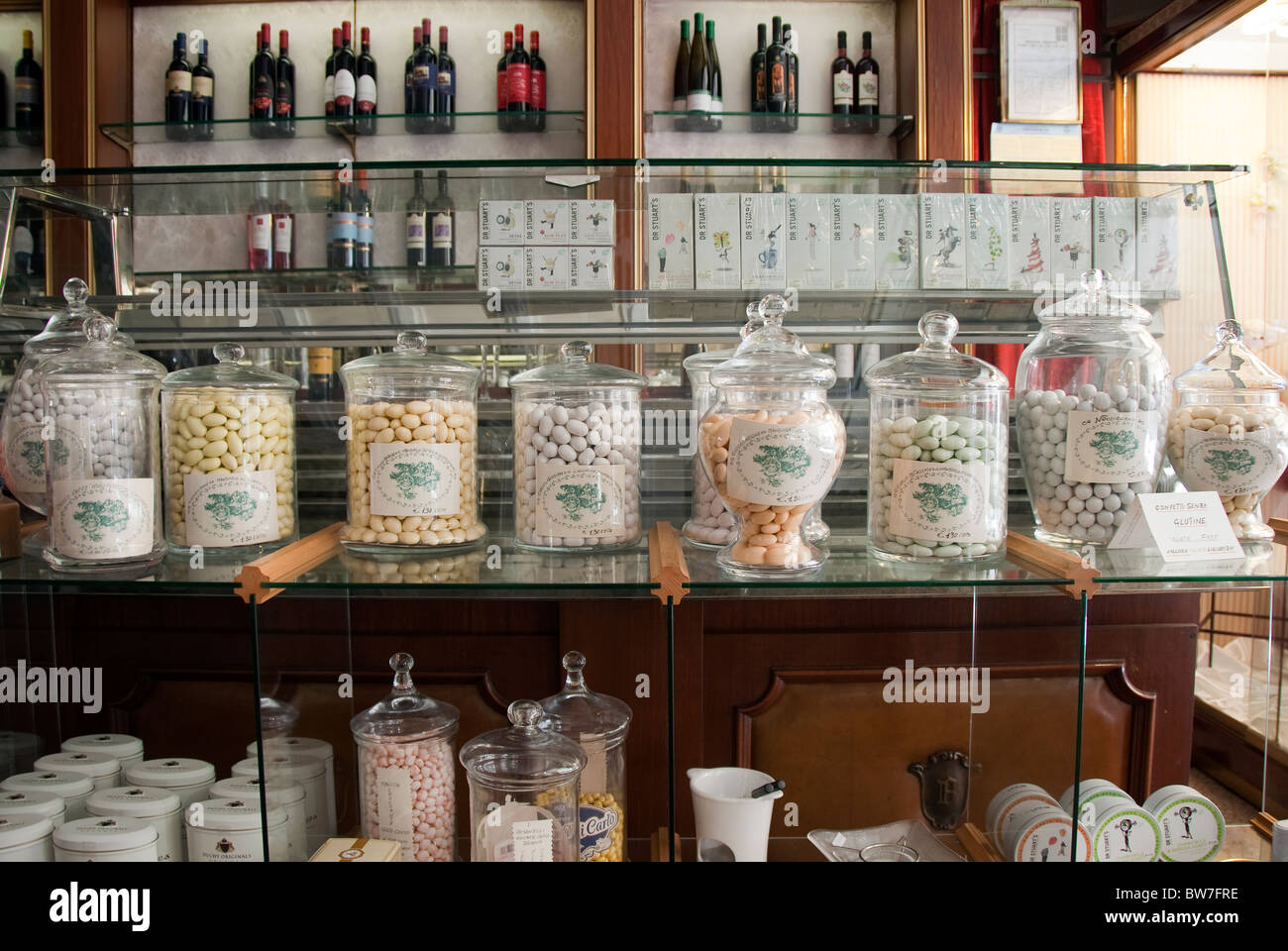 Confetti in vasetti di vetro su un ripiano a Bardi una famosa pasticceria o cake shop) a Jesi, Le Marche, Italia Foto Stock