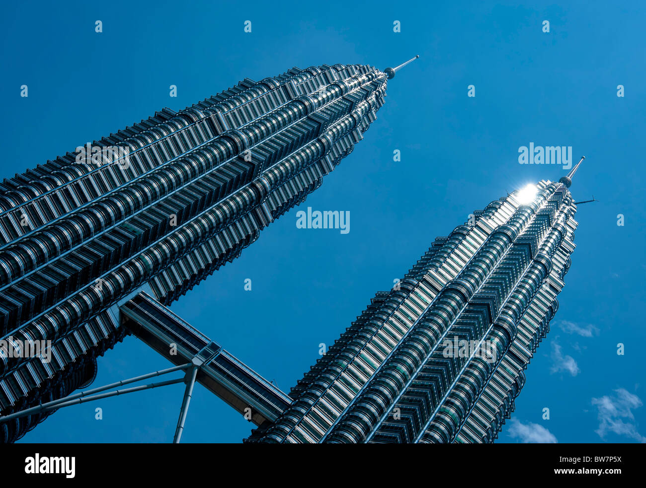 Torri PetronasTwin Kuala Lumpur in Malesia. Prese ad un angolo di sole glinting off le torri di metallo contro un cielo blu Foto Stock