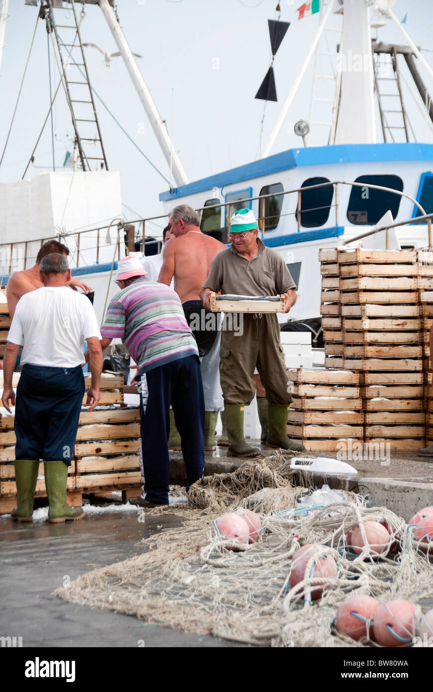 Caricamento dei pescatori nelle casse di pesce fresco catturato da una barca fuori Porta Garibaldi sul Delta del Po, Emilia Romagna, Italia Foto Stock