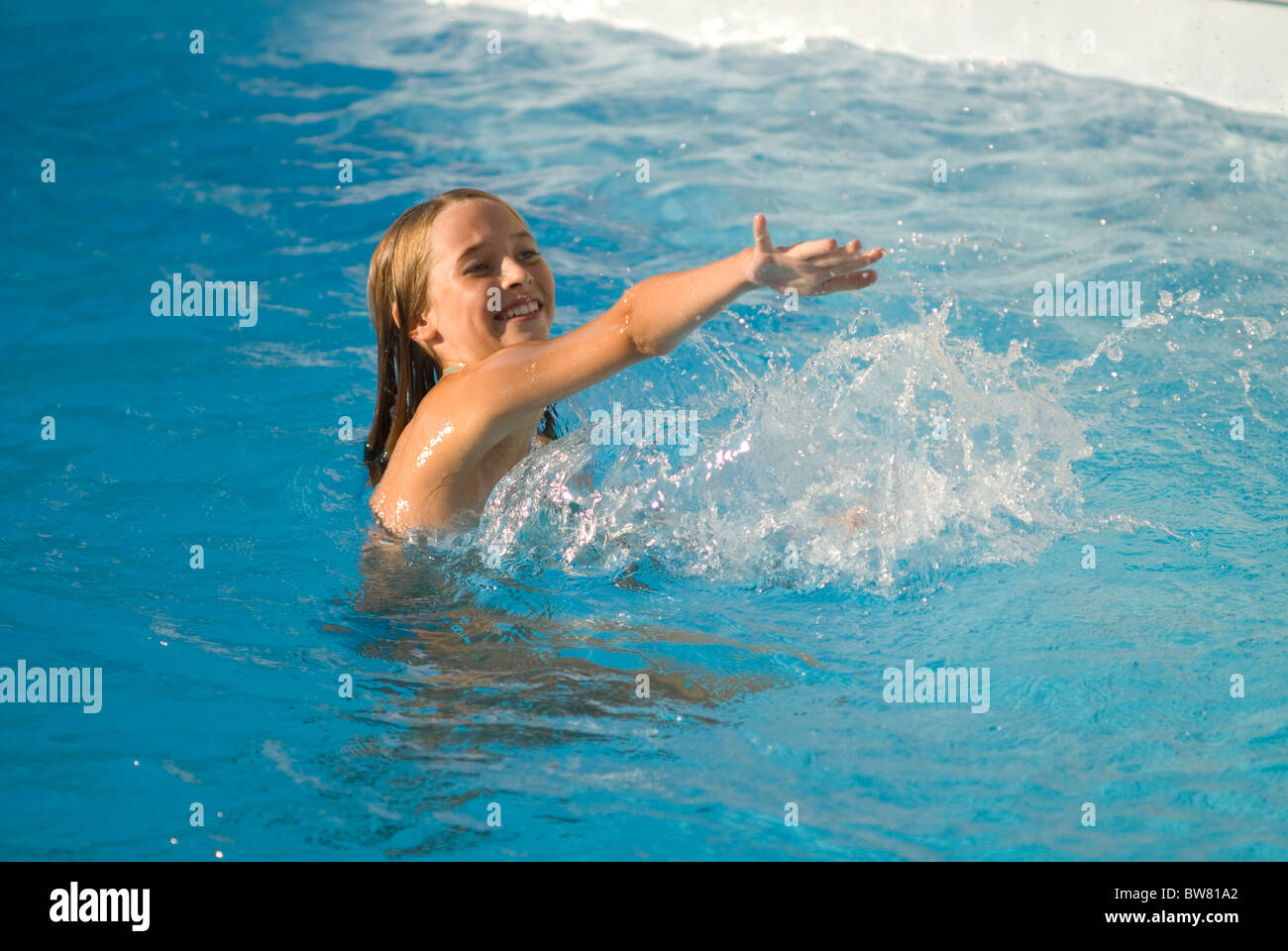 Giovane ragazza a giocare in piscina Foto Stock