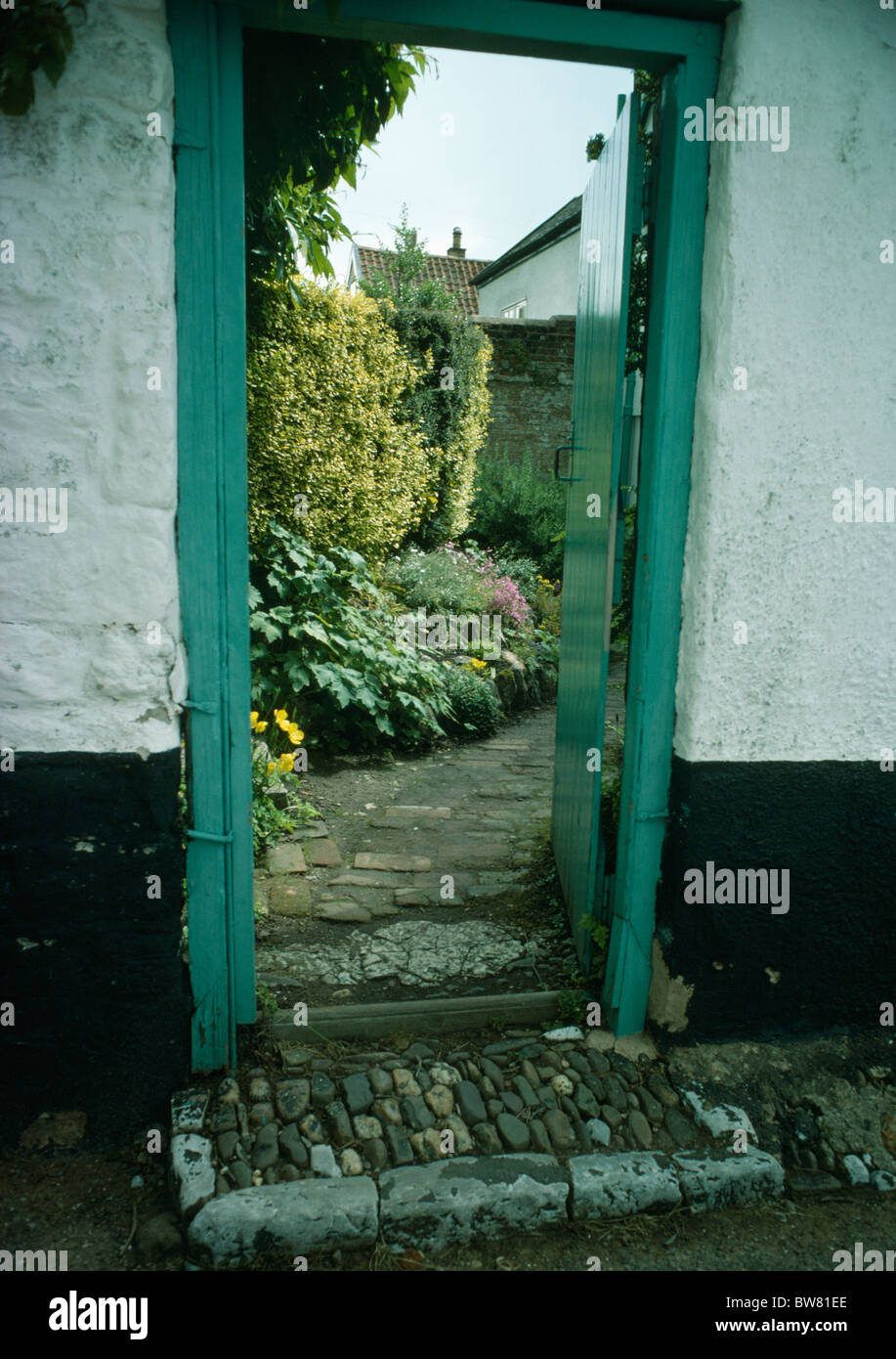 Giardino murato con la porta aperta ad un piccolo giardino interno Foto Stock
