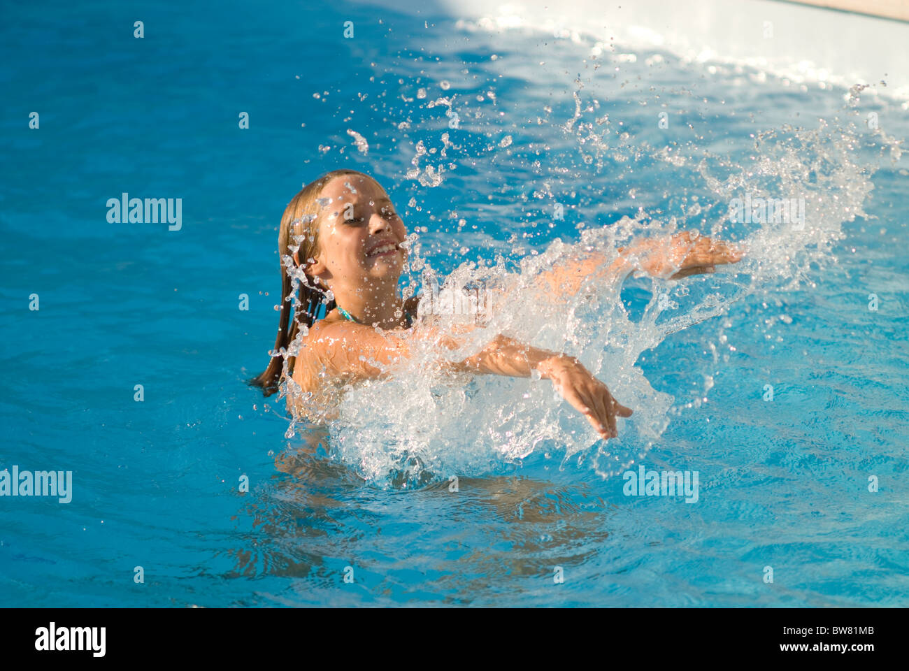 Giovane ragazza a giocare in piscina Foto Stock