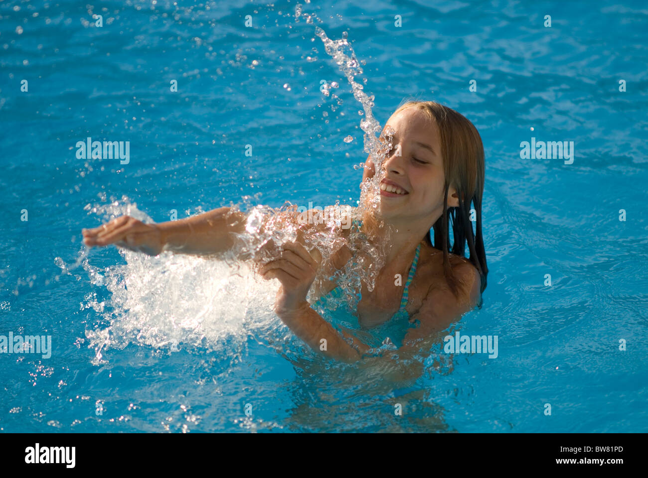 Giovane ragazza a giocare in piscina Foto Stock