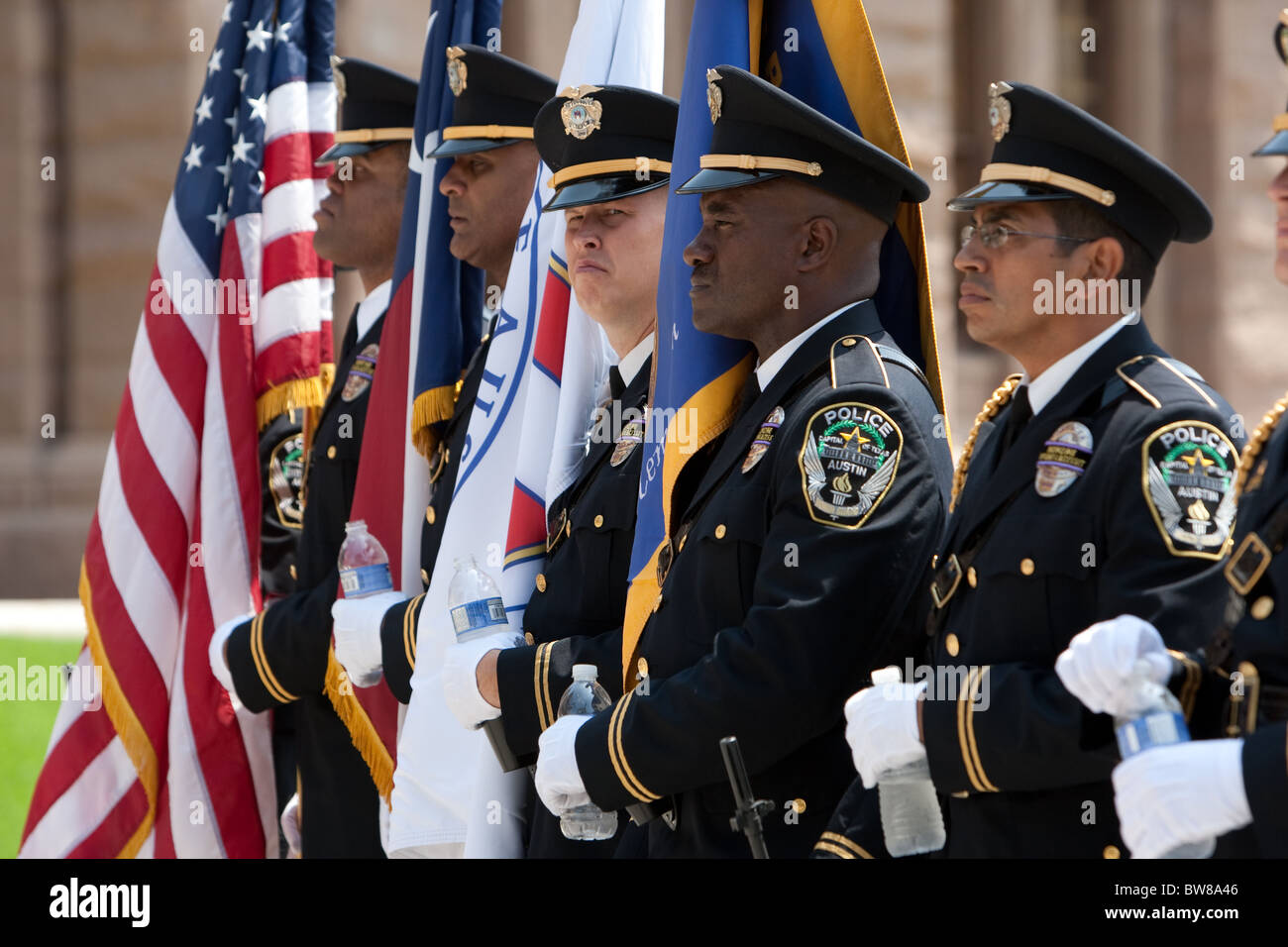 Multi-etnico gruppo di funzionari di polizia presenti flag di guardia di colore durante la pace ufficiali Giorno Memoriale della cerimonia di Austin in Texas Foto Stock