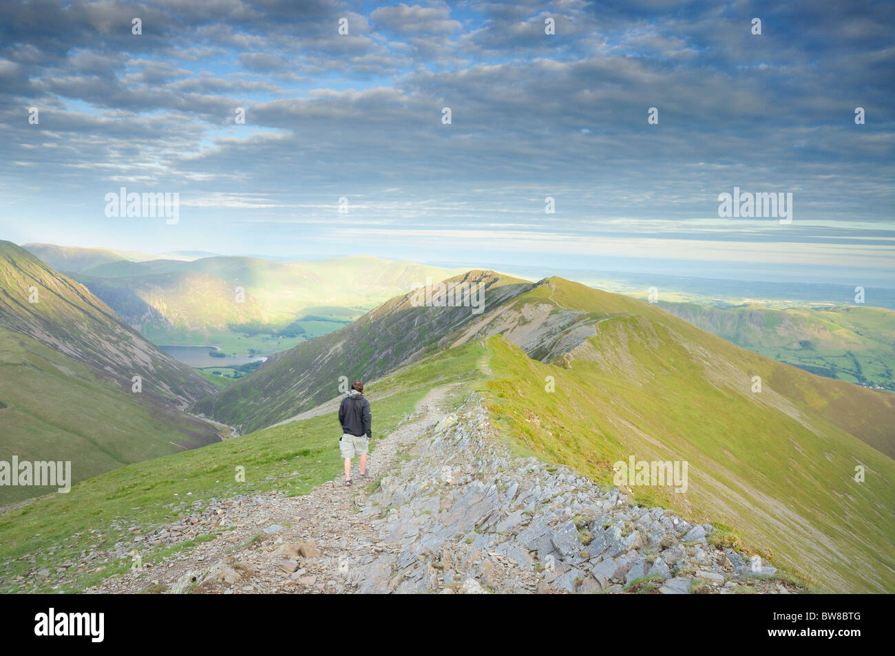 Walker sul vertice della testa Hopegill cercando lungo il crinale di Whiteside nel Lake District inglese Foto Stock