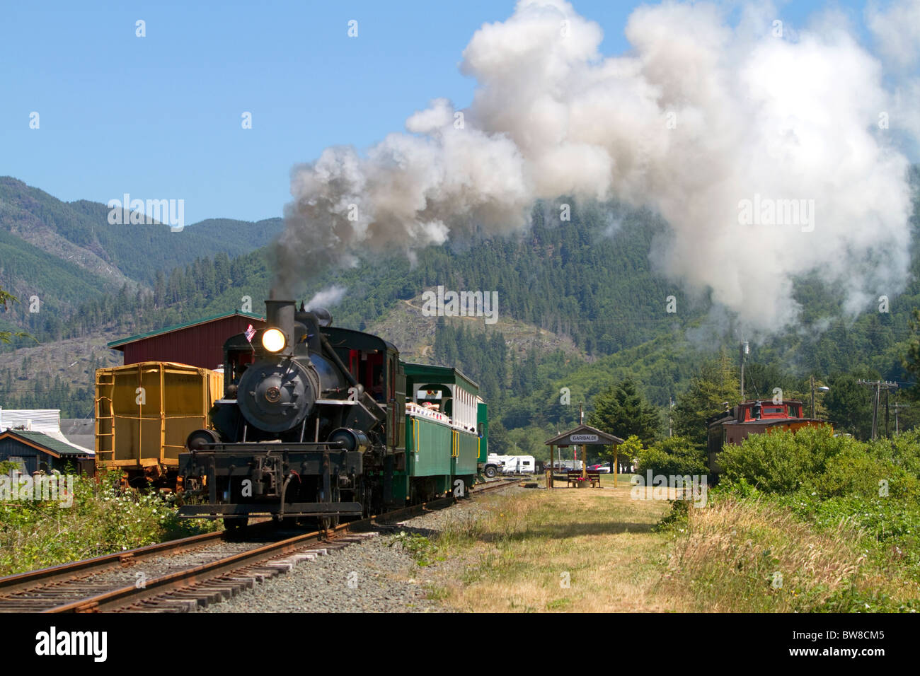 I turisti di marcia dietro un 1910 Heisler locomotiva a vapore a Garibaldi, Oregon, Stati Uniti d'America. Foto Stock