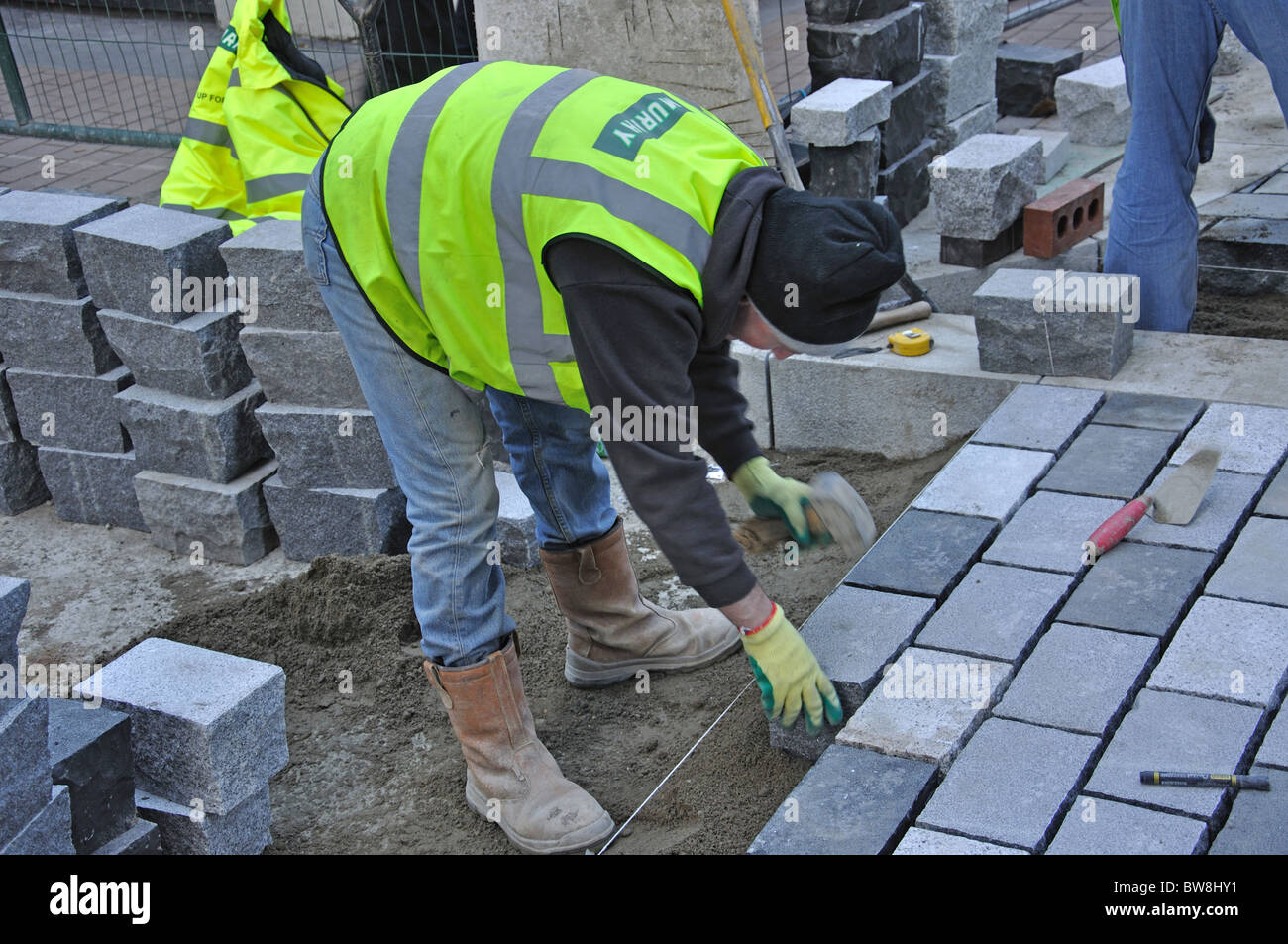 Workman posa di nuova pavimentazione di pietra, Carnaby Street, Soho, West End, la City of Westminster, Greater London, England, Regno Unito Foto Stock