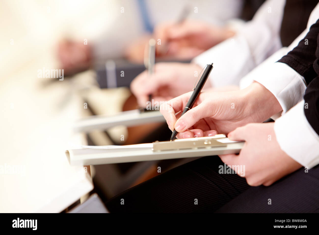 Close-up di persona d'affari le mani con la scrittura del documento durante la conferenza Foto Stock