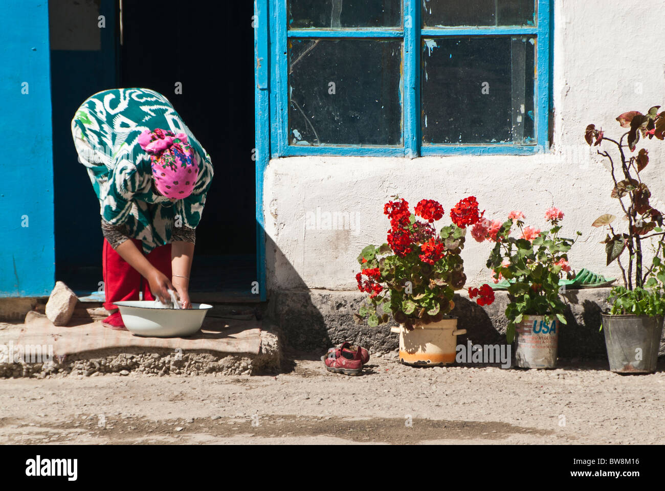 Donna con lavabo e fiori, Murgab, il Pamir highway, in Tagikistan, in Asia Foto Stock