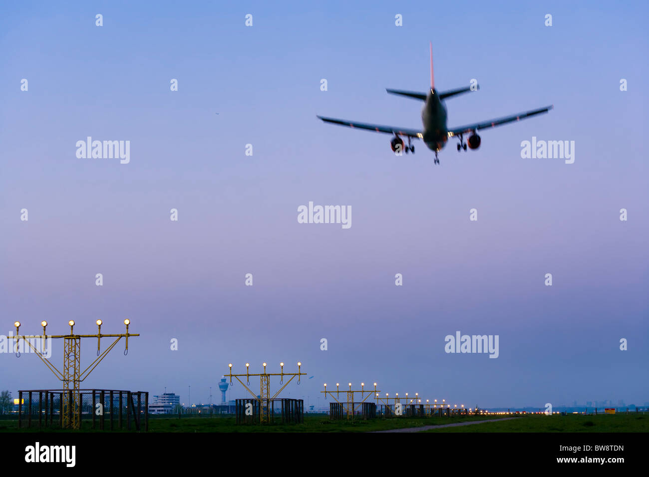 Aeroporto Schiphol di Amsterdam al crepuscolo. Piano aereo di avvicinamento e di atterraggio, sulla pista Kaagbaan. Foto Stock