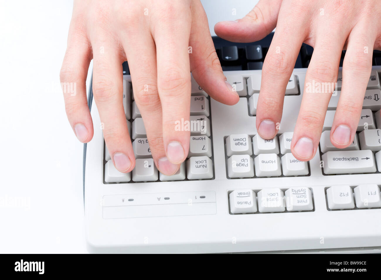 Angolo di sopra dei maschi di mani toccano pulsanti di bianco della tastiera del computer Foto Stock