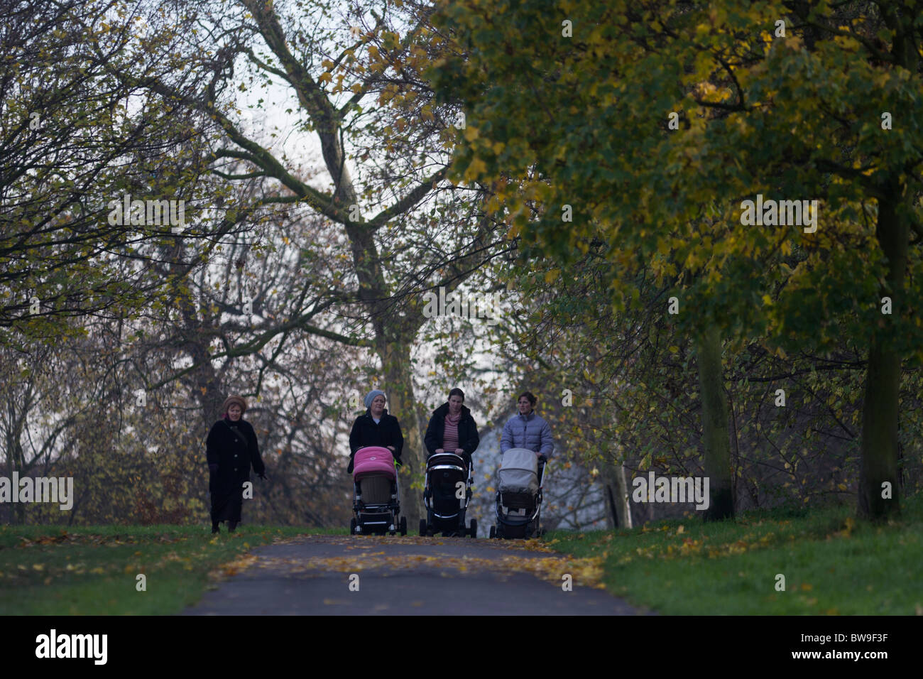 Locali di madri e bambini nei passeggini a piedi attraverso il parco Brockwell, Herne Hill, Londra del sud. Foto Stock