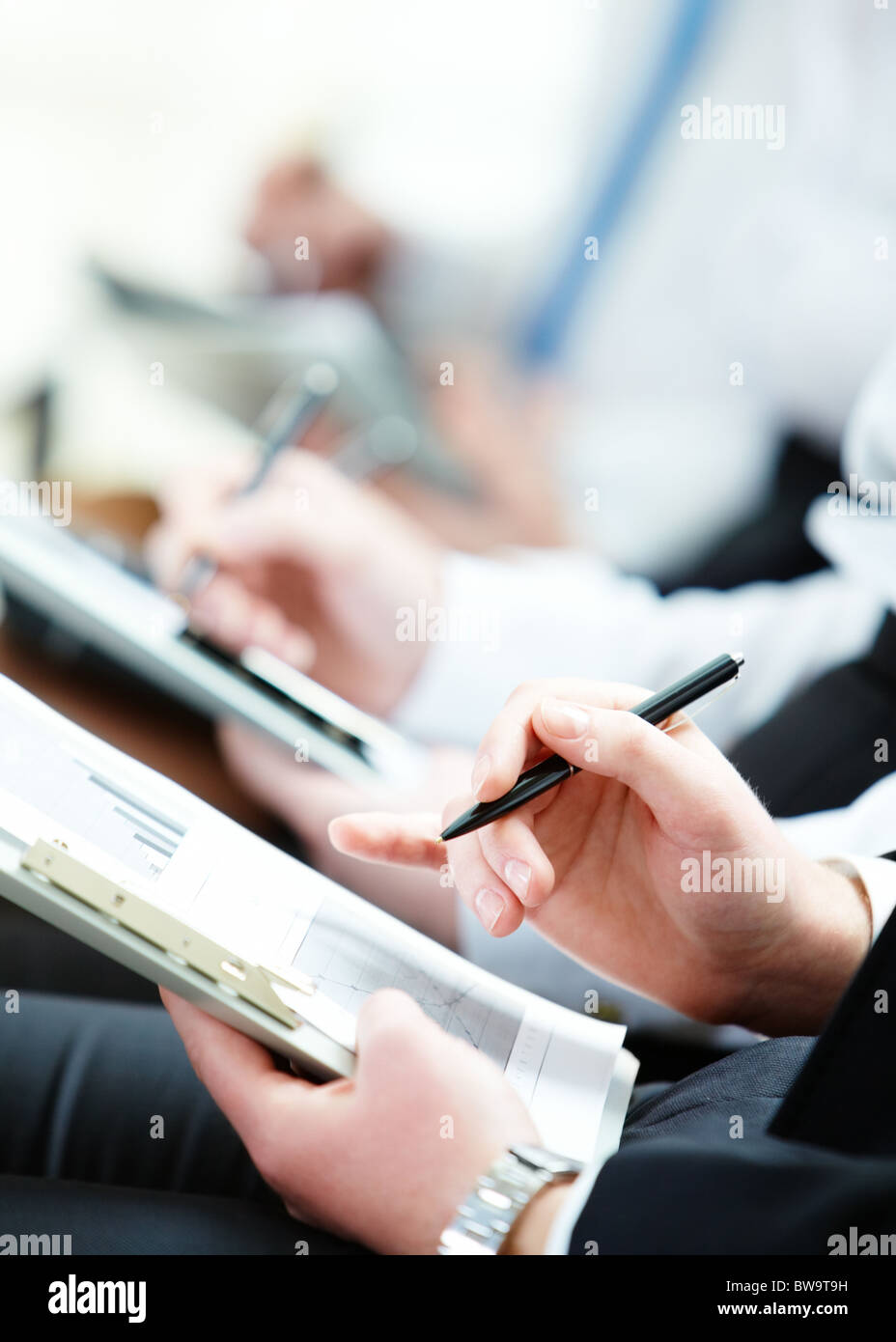 Persona d'affari mano con la penna rivolta al documento durante la lezione Foto Stock