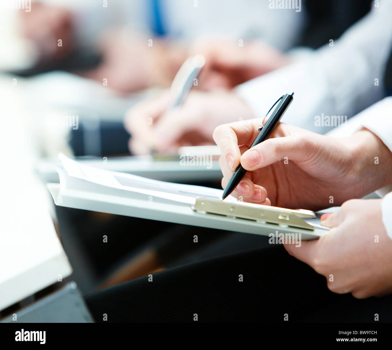 Close-up di persona d'affari le mani con la scrittura di documenti durante la conferenza Foto Stock