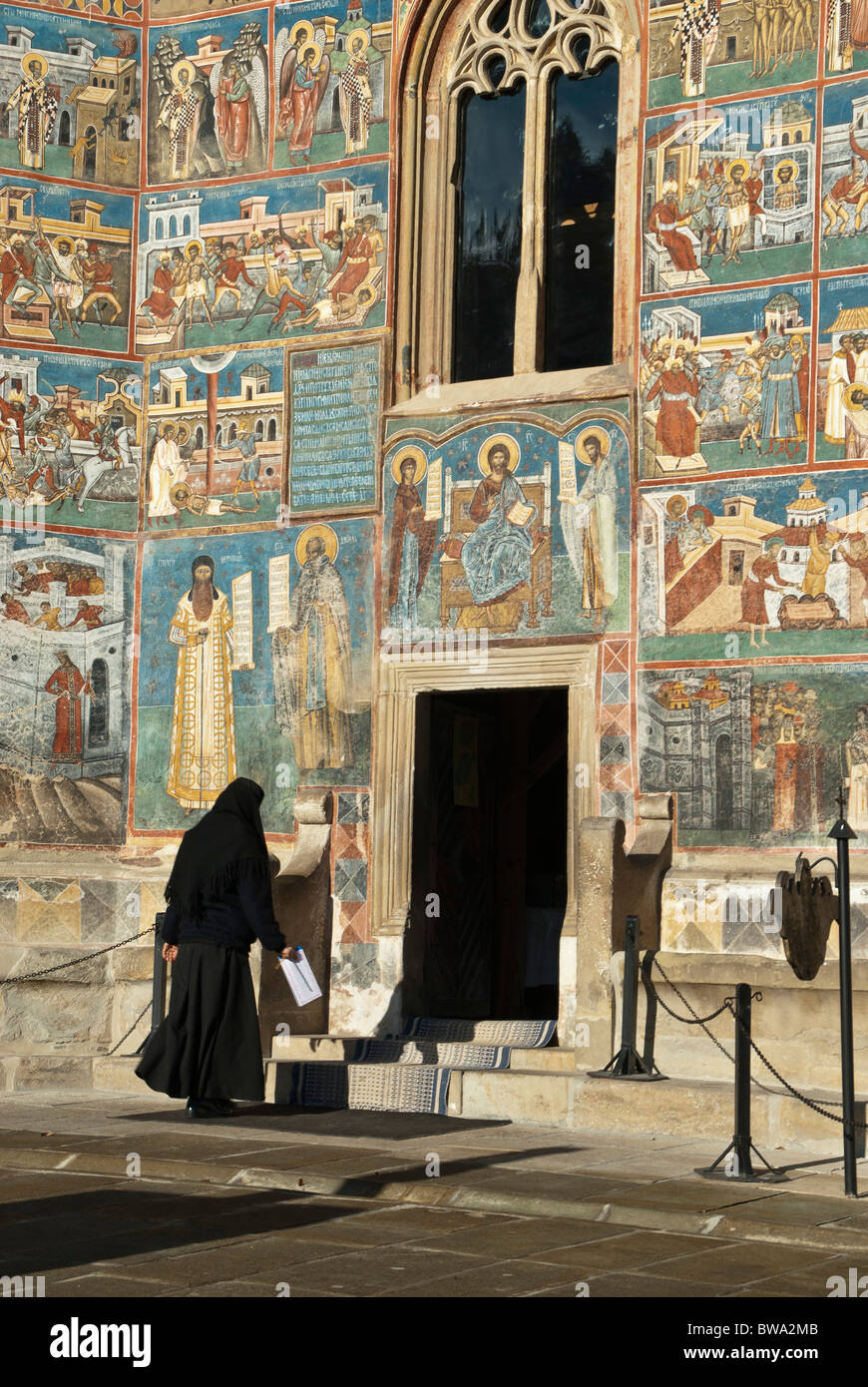 Nun entrando in uno dei monasteri dipinti della Bucovina, la Romania, l'Europa. Foto Stock