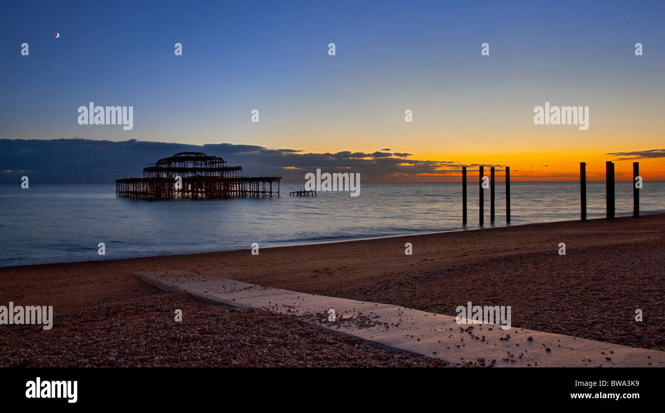 Il vecchio molo Ovest al tramonto, Brighton East Sussex, Inghilterra Foto Stock