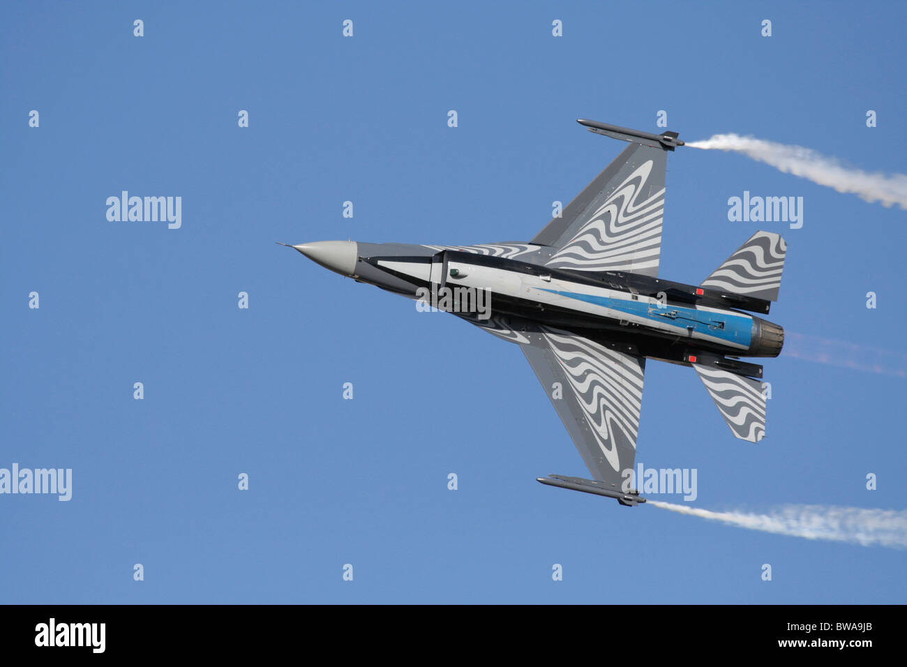 Aereo da combattimento belga F-16 che vola nel cielo durante un'esposizione aerea. Vista dal basso. Composizione fuori centro con spazio di copia. Foto Stock
