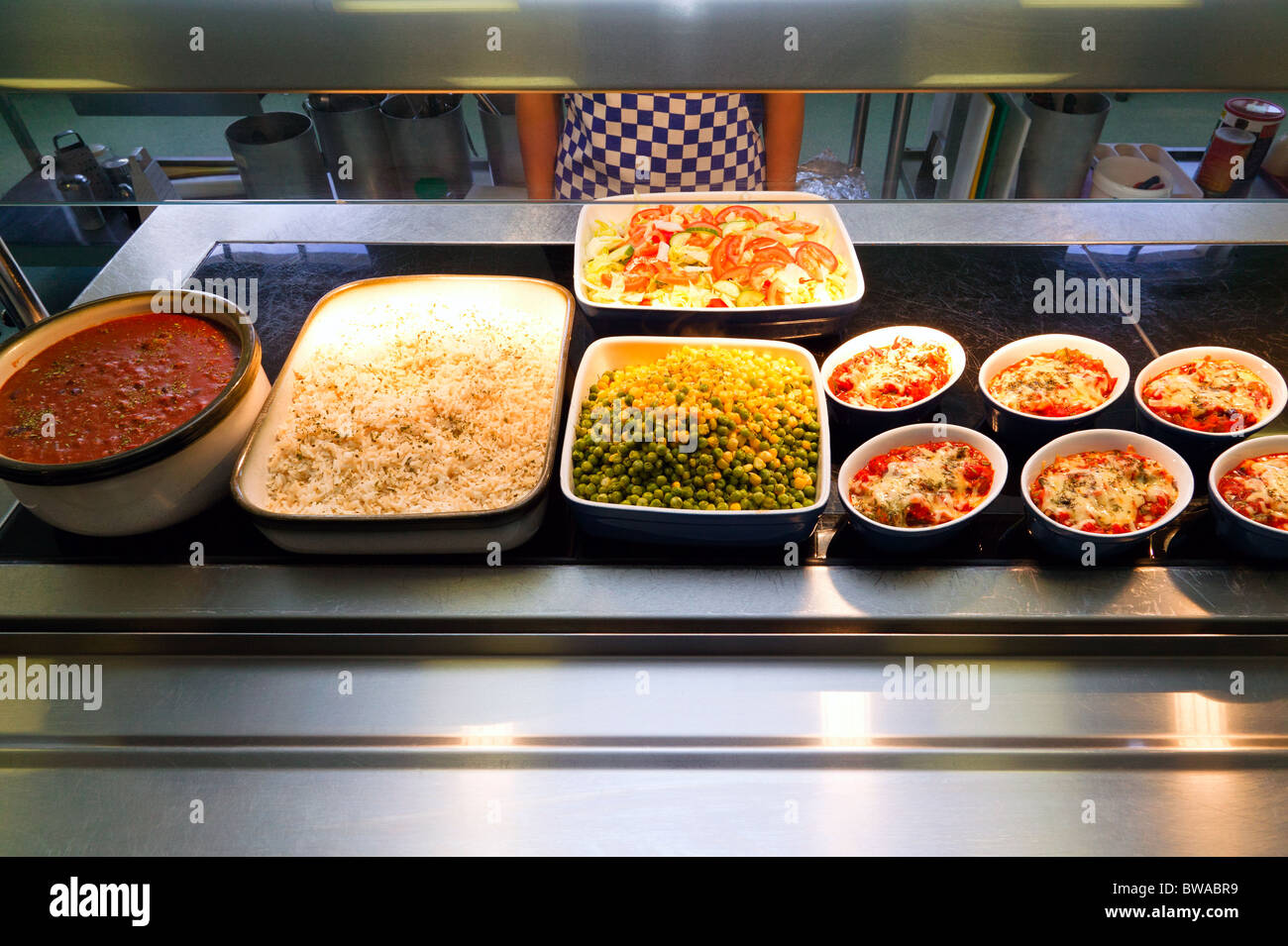 Un cibo caldo che serve contatore in una mensa con una selezione di pasti Foto Stock