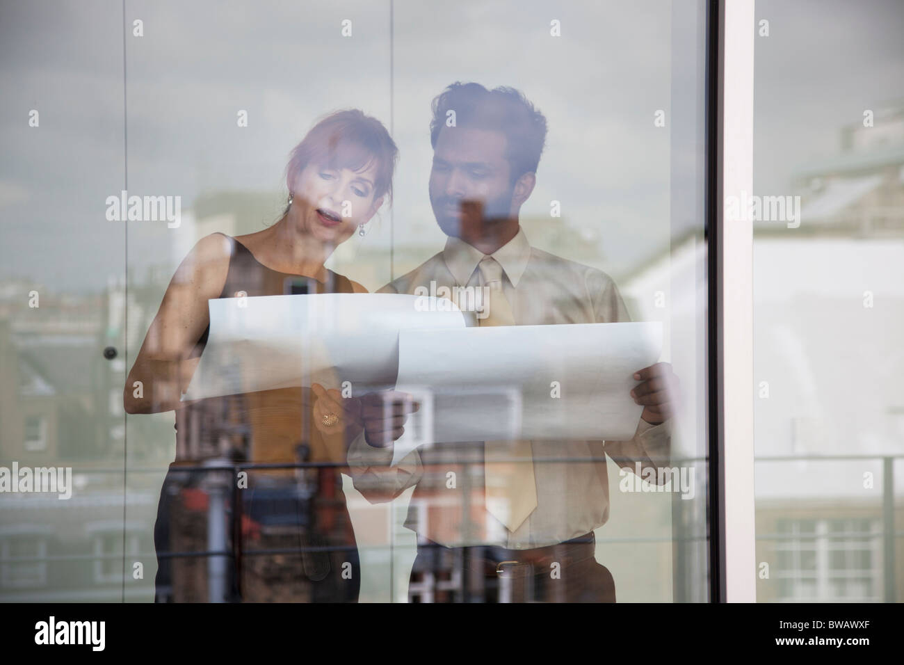 Due colleghi di lavoro per discutere di documenti cartacei Foto Stock