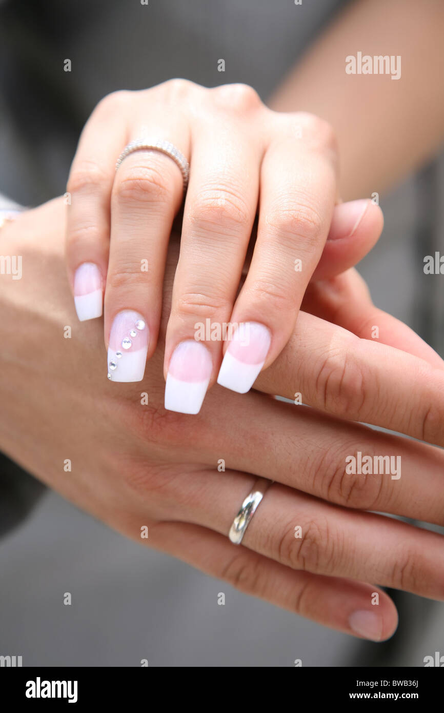 Close-up di sposa la mano su quella del marito dopo scambio di anelli di nozze Foto Stock