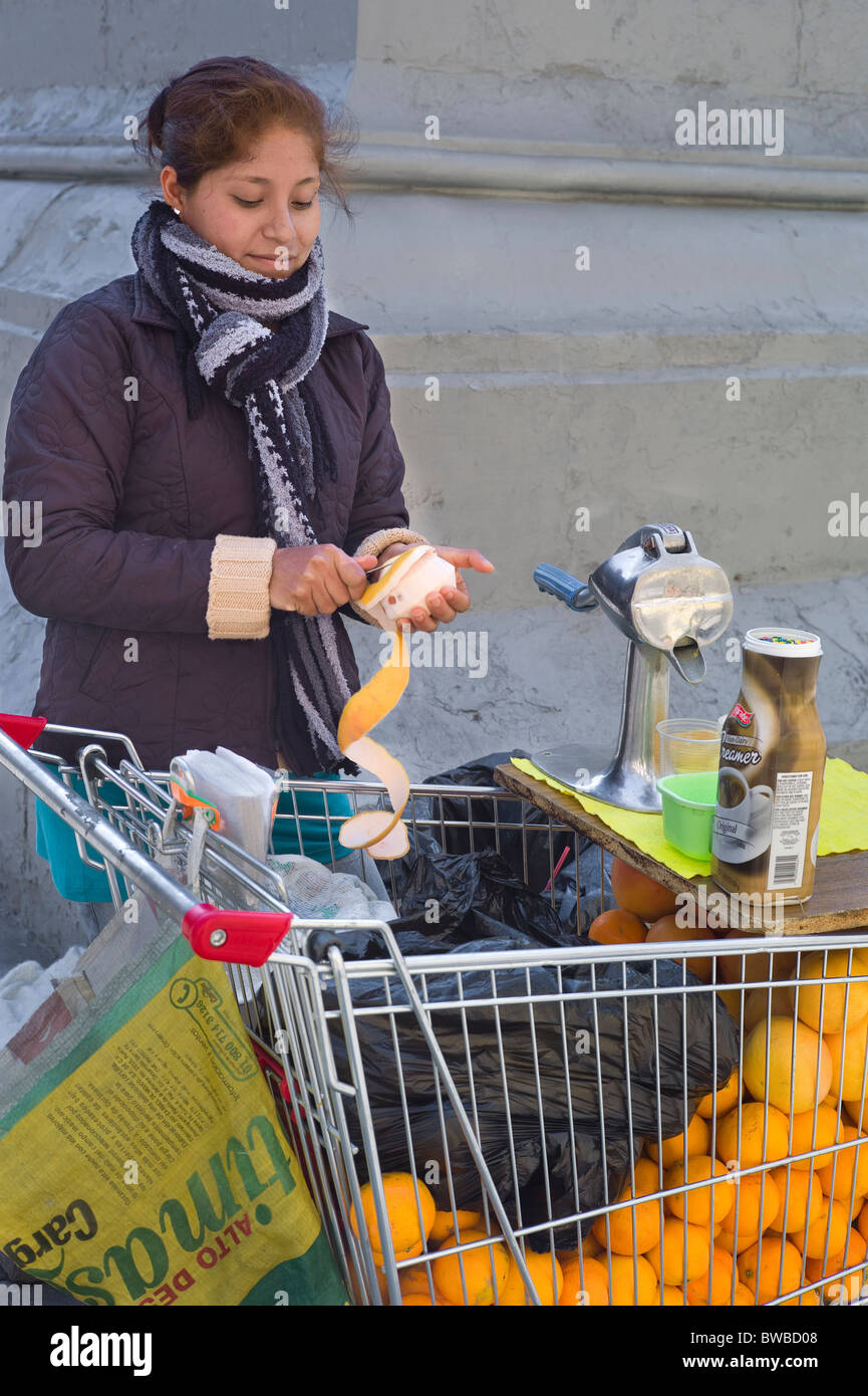 Venditore ambulante Sbucciare le arance in preparazione per la spremitura di succhi di frutta, Santiago del Cile Foto Stock